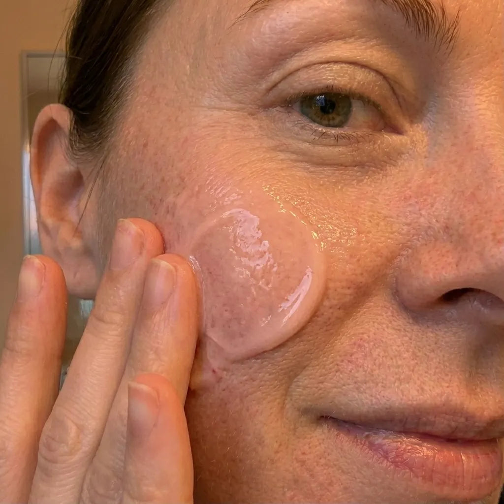 Close-up of a person applying kynde peptide renewal serum to their face